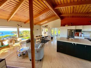 a kitchen and living room with a view of the ocean at Kereru at Kaiteriteri - Kaiteriteri Holiday Home in Kaiteriteri