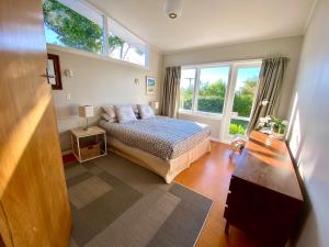 a bedroom with a bed and a large window at Kereru at Kaiteriteri - Kaiteriteri Holiday Home in Kaiteriteri