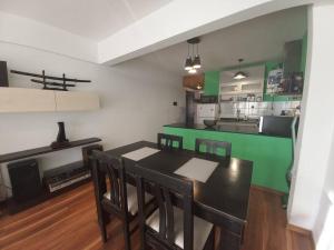 uma sala de jantar com uma mesa e uma cozinha verde em Acogedor y Luminoso 2 Ambientes Centro Morón em Morón