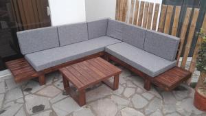 a gray couch and two wooden tables on a patio at Casa en cineguilla in Cieneguilla