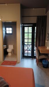 a room with a bathroom with a toilet and a desk at BRICKS Cameron Hostel in Tanah Rata