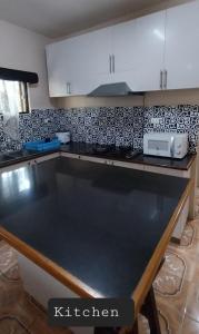 una cucina con piano di lavoro nero in una camera di Chands Apartment a Lautoka