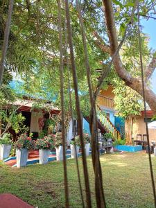 una casa con árboles frente a un patio en Raj Mahal Inn en Wadduwa