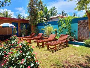 a group of benches in a yard with flowers at Raj Mahal Inn in Wadduwa