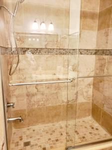 a bathroom with a shower with a glass door at The Farm House in Sanford