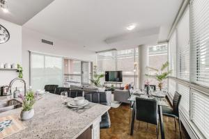 a kitchen and living room with a table and chairs at Upscale 2BR Condo - King Bed - Stunning Views in Calgary