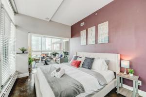 una camera da letto con un grande letto bianco e pareti viola di Upscale 2BR Condo - King Bed - Stunning Views a Calgary