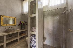 a bathroom with a shower and a sink and a toilet at RiverView Gardens in Ubud