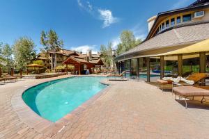 una piscina con sillas y una casa en Trappeurs Lodge 1107, en Steamboat Springs