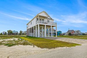 uma casa branca na praia com um campo de relva em Sol Vacation em Freeport