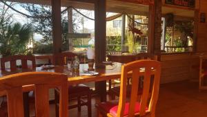 a dining room with a wooden table and chairs at Hostal Mesa del Mar in Villarrica