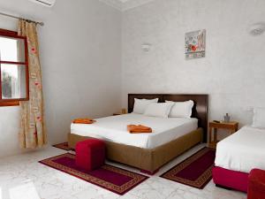 A bed or beds in a room at Guest House Qodwa