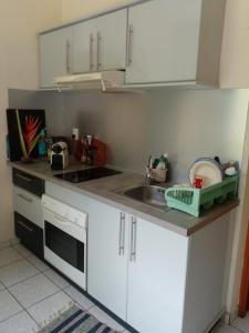 a kitchen with white cabinets and a sink at Holidays in Martinique - Ravenala in Sainte-Anne +16 photos