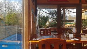 a dining room with a table and a glass window at Hostal de Luz in Villarrica