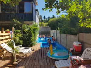 a backyard with two pools with people playing in them at Hostal Mesa del Mar in Villarrica +23 photos