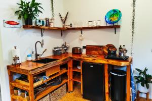 cocina con encimera de madera y fregadero en Adventurer's Chest - Pohutukawa, en Hotwater Beach