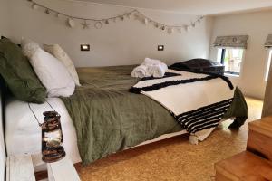 1 dormitorio con 1 cama grande y toallas. en Adventurer's Chest - Pohutukawa en Hotwater Beach