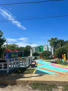 Eco Hostal Villa Canada - A Sustainable Oasis on Isla de Tierra Bomba في Playa Punta Arena: حديقة مع ملعب مع زحليقة