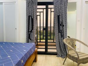 1 dormitorio con 1 cama, 1 silla y 1 ventana en Résidence El Hadji Annexe, en Dakar
