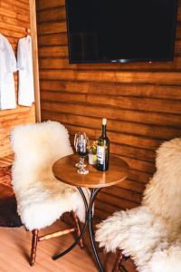 uma mesa com uma garrafa de vinho e duas cadeiras em Hospedagem Cabanas do Lago Urubici em Urubici