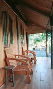 dos bancos sentados en el porche de una casa en TINA LAKESIDE AO ĐÔI Homestay Phước Hải, en Hội Mỹ