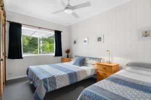 1 dormitorio con 2 camas y ventana en AXL Orion Beach Home: Beach front, en Vincentia