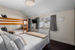 1 dormitorio con 2 camas y ventana en Kooloora Lodge, en Perisher Valley