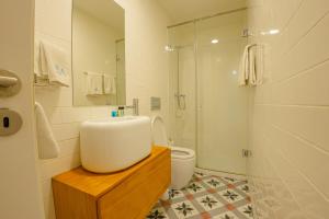 a bathroom with a sink and a toilet and a shower at Belas Artes Apartments in Porto