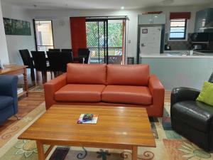 a living room with a couch and a coffee table at 11 Manooka Drive Rainbow Beach in Rainbow Beach