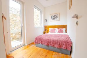 sypialnia z łóżkiem i dużym oknem w obiekcie Belas Artes Apartments w Porto