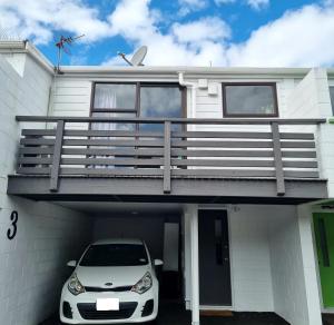 um carro estacionado em frente a uma casa com garagem em Linden Lodge Haven em Wellington