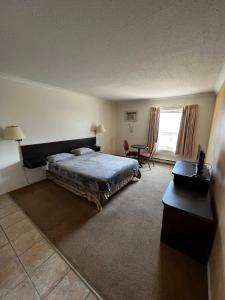 利盧艾特的住宿－維多利亞酒店，一间卧室配有一张床和一张桌子
