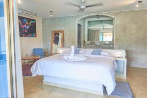 a bedroom with a white bed and a mirror at Hotel Casa Justina in Puerto Ángel +74 photos