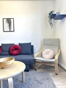 a living room with a blue couch and pink pillows at Stunning 2-bed apt near central London. in London