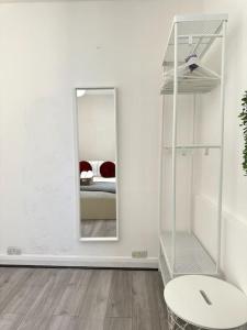 a white room with a mirror and a bed at Stunning 2-bed apt near central London. in London