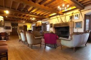 a living room with chairs and a fireplace at The Manor at Plane Castle in Falkirk