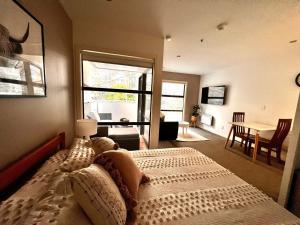 a bedroom with a bed and a table and a window at Studio Apartment in Auckland CBD in Auckland