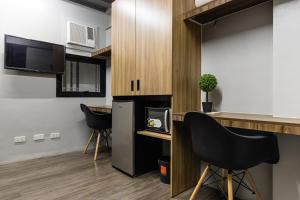 a kitchen with a counter and chairs in a room at District Inn in Manila