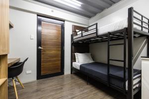 a bedroom with two bunk beds and a door at District Inn in Manila