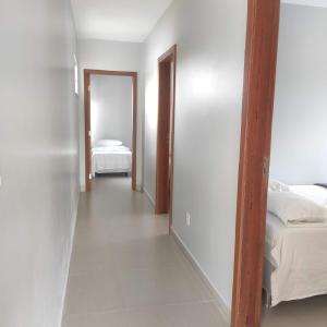 um quarto com duas camas e um corredor com um espelho em Casa de praia em Sauipe em Porto de Sauípe