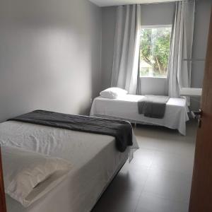 Duas camas num quarto com uma janela em Casa de praia em Sauipe em Porto de Sauípe