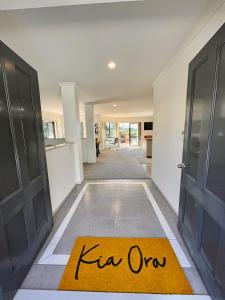 a hallway with an open door with a kir open rug at Abeam of Reserve Living in Rotorua