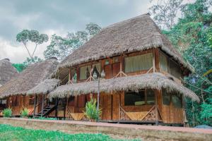 un grupo de cabañas con techo de paja en Caiman Eco Lodge, en Aguarico