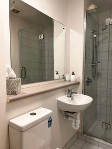 a bathroom with a toilet and a sink and a shower at Studio Apartment in Auckland CBD in Auckland