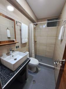 a bathroom with a sink and a toilet and a shower at Rockrivers MachuPicchu in Machu Picchu