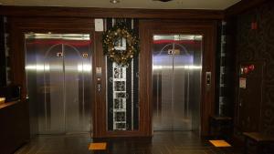 a hallway with two elevators in a building at Sky Hotel in Hwaseong
