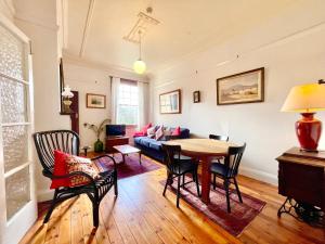 sala de estar con mesa y sofá en Violet's Maison en Katoomba