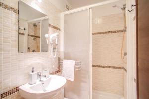 a bathroom with a white sink and a shower at Hotel Mosaic Central Rome in Rome
