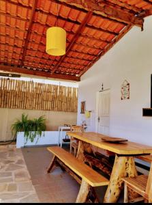 a room with a wooden table and benches at CASA ALUNAI in Pirenópolis