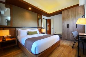 a bedroom with a large bed and a desk at Sotogrande Hotel Palawan in Puerto Princesa City